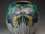 un vase avec des fleurs peintes dessus, posé sur une table