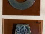 two pictures of a metal object on display in a glass case