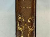 un livre marron orné de motifs dorés sur fond blanc