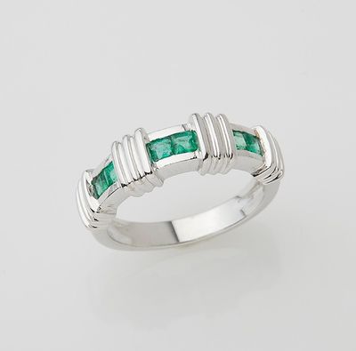 a white gold ring set with emerald stones