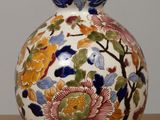 a vase with a floral design on it sitting on a table