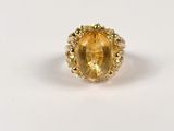a close up of a ring with a yellow stone in it