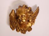 a gold statue of an angel on a white wall
