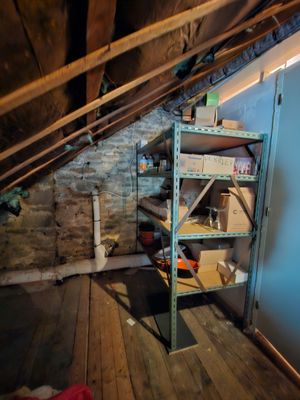 a room that has a shelf in the corner of the room