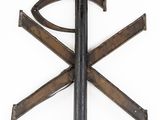 a metal object with a cross on it on a white surface