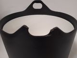 the black and white bowl is sitting on a white surface