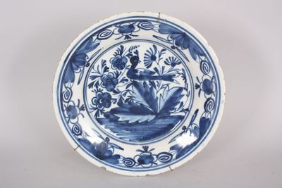 une vieille assiette bleue et blanche représentant une femme sur un bateau