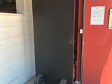 a large black piece of furniture sitting on the floor in front of a red wall