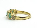 an image of a close up of a gold ring with a green stone