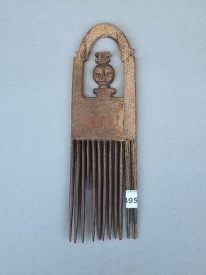 un peigne en bois orné d'un oiseau, posé sur une table