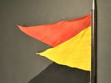 a red, yellow, and black flag on a pole