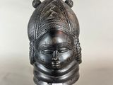 a black sculpture of a woman ' s head on a black stand