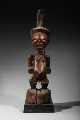 une statue en bois d'un homme avec un chapeau sur la tête