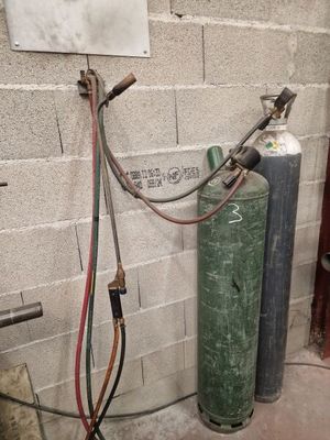 un extincteur fixé au mur à côté d'une borne d'incendie
