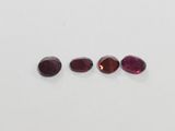 three oval cut garnets of different colors and sizes
