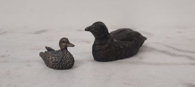 deux canards assis côte à côte dans la neige