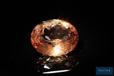 a close up of an orange diamond on a black surface
