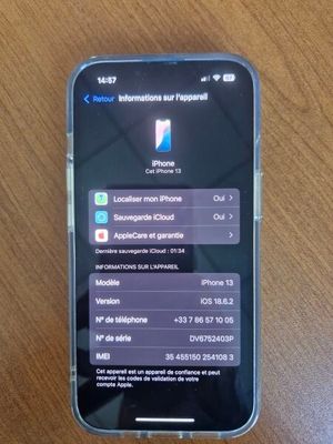 Quelqu'un est en train de tester l'application sur son iPhone, posé sur une table en bois.