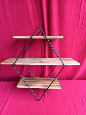 a three tiered wooden shelf with a metal frame on a pink background