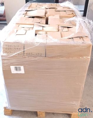 a large pile of boxes sitting on a pallet in the middle of a room
