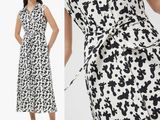 une femme vêtue d'une robe noire et blanche et de sandales