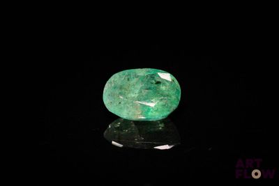 un gros plan d'une émeraude verte sur une surface noire