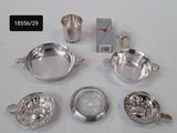 silver plated teapots, cups and saucers are on a white surface