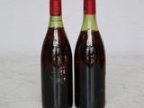 two bottles of wine sitting on top of a marble counter top