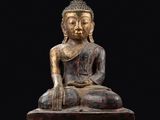 une statue de Bouddha assis sur un bloc de bois
