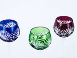 four wine glasses are lined up in a row on a white surface