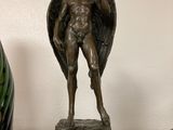 une statue d'ange posée sur un socle, à côté de deux vases