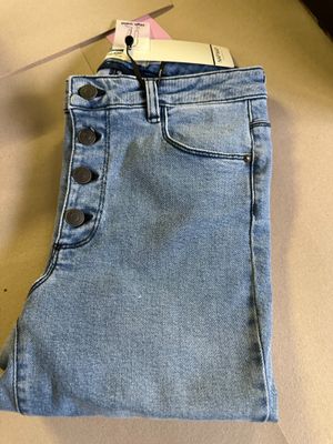 a close up of a pair of jeans hanging on a hanger