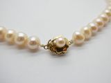 gros plan d'un collier de perles sur une surface blanche