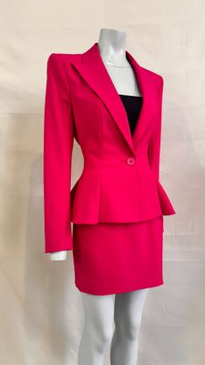 the mannequin is wearing a bright pink suit and black top