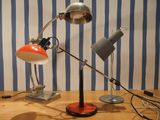 deux lampes posées sur une table, avec en arrière-plan un mur rayé de bleu et de blanc