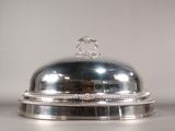 un plat en argent avec un couvercle en argent posé sur une table