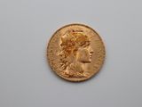 a close up of a gold coin with a woman ' s head on it