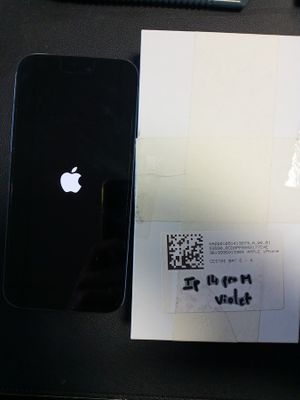 un iPhone noir posé sur une table, à côté d'un téléphone portable