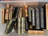 de nombreux livres anciens dans une boîte en plastique posée sur une table