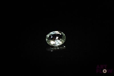 a close up of a green diamond on a black surface