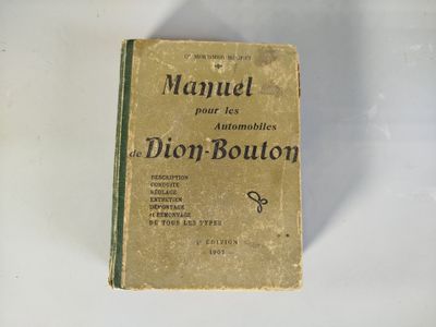 un vieux livre posé sur une table blanche, à côté d'une paire de ciseaux