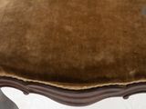 an upholstered stool with a brown velvet seat and a wooden frame