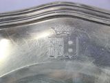 a silver plate with a coat of arms and a crown on it