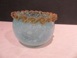 a blue vase with a gold rim sitting on a table