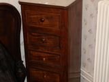 une petite commode posée à côté d'un lit dans une chambre