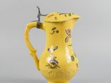 an image of a yellow pitcher with flowers and birds on it