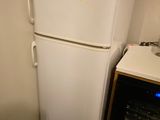 a white refrigerator with a yellow sticker on it in a kitchen