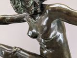 bronze statue of a woman in a pose on a marble base
