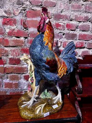 une statue représentant un coq posé sur une table en bois