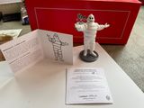 une petite figurine représentant un homme, les deux mains posées sur une table